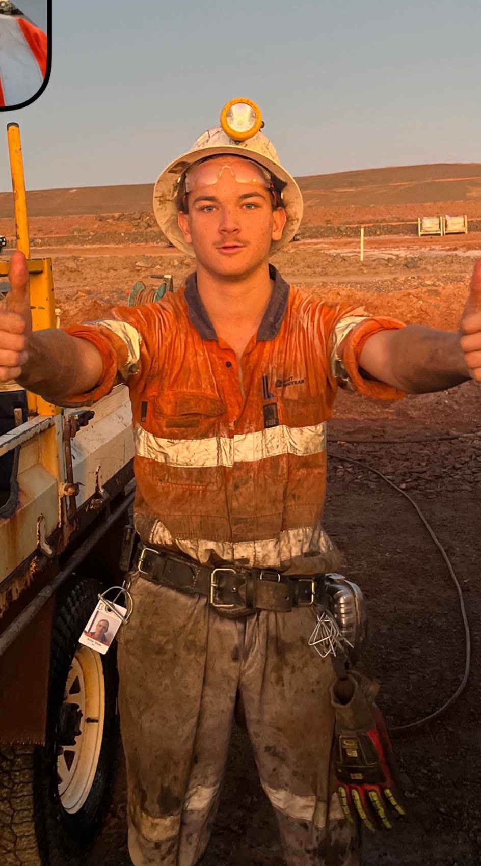 Asher on site at the end of a shift, in hi-vis and a hard hat.